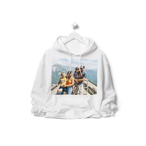 White hoodie hanging on a rail with a full-colour family photo in the mountains